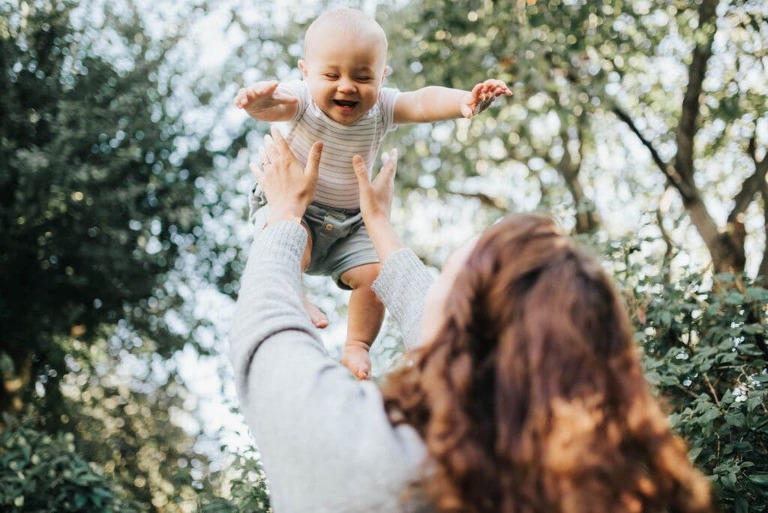 Portrait of a seven month old baby giggling at mum